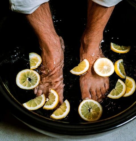 “Man enjoying a refreshing lemon foot spa soak at Lotus Men’s Spa in Anantapur — natural detox and relaxation therapy to cleanse, refresh, and rejuvenate tired feet.”