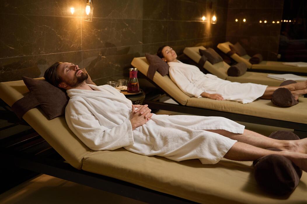“Man relaxing in a luxury spa lounge wearing a white robe at Lotus Men’s Spa in Anantapur — peaceful wellness environment designed for comfort, rest, and rejuvenation.”